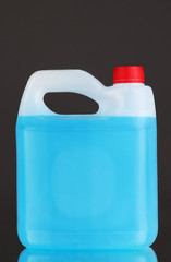 Blue liquid for car in canister on grey background