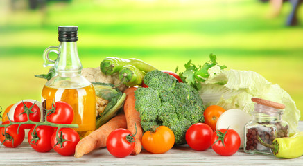 Fresh vegetables in basket on wooden table on natural