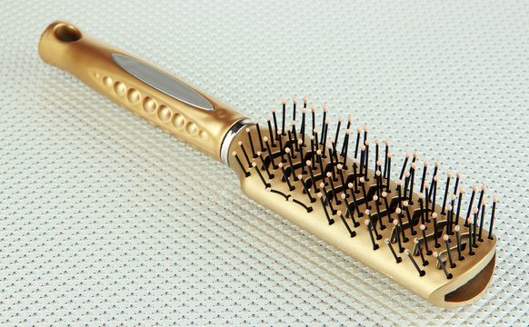 Hairbrush on color background