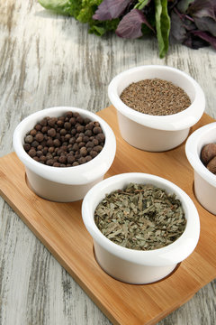 Assortment of spices in  white  bowls, on wooden background