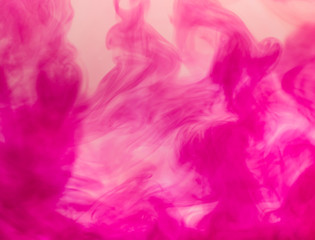 Pink watercolor in water.