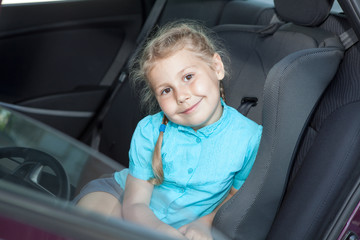 Small Caucasian girl in car safety seat going to journey