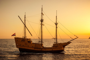 Medieval sailing ship in sunset