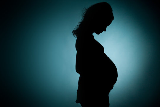 silhouette of pregnant young lady in studio