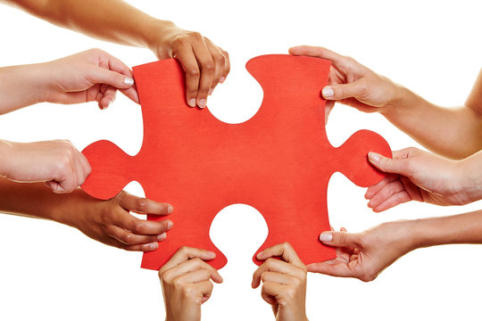 Hands holding red jigsaw puzzle