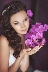 Bride at wedding day with makeup and hairstyle, holding bouquet