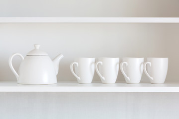 Fototapeta na wymiar teapot and cups on the shelf