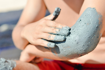 Man applying mineral blue mud on elbow