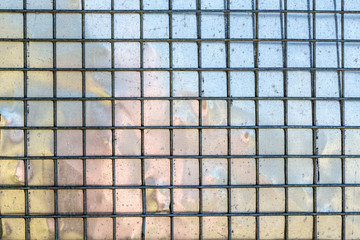 metal grid with mirroring surface in background