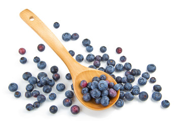 The composition of the blueberries in a wooden spoon