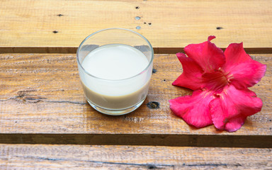 milk in glass and red  flower
