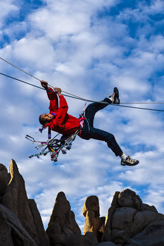 Climber pulls across a tyrollean traverse.