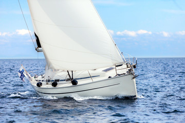 Sailing boat on open sea sailing on port tacks