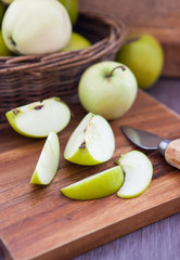 Sliced green apple on wooden cutting board