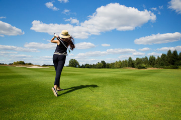 portrait of young female golf player, back view