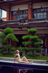 The sunbathing woman near a swimming pool