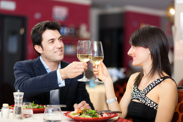 Couple toasting wineglasses in a luxury restaurant