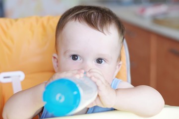 Baby drinks milk from small bottle