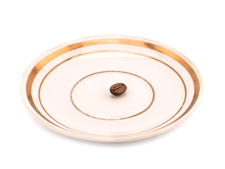 One coffee grain on a white plate.