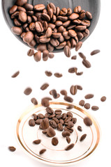 Falling coffee beans, white and black saucer