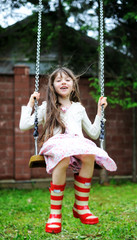 Elegant child girl swinging in the park