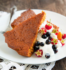 Piece of carrot cake with whipped cream and berries