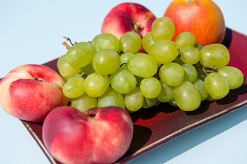 Naklejka na ściany i meble grapes and peaches in a bowl