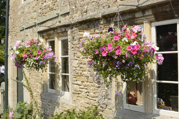 Fototapeta na wymiar Cottage with hanging flower baskets. Wiltshire. England