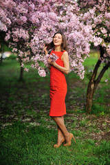beautiful young woman in spring garden near blooming tree