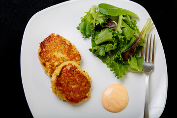 Crab Cakes and Salad on Black From Above
