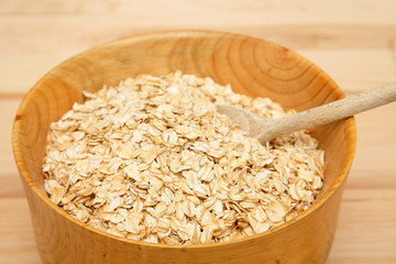 Bowl of Dry Oats with Wood Spoon