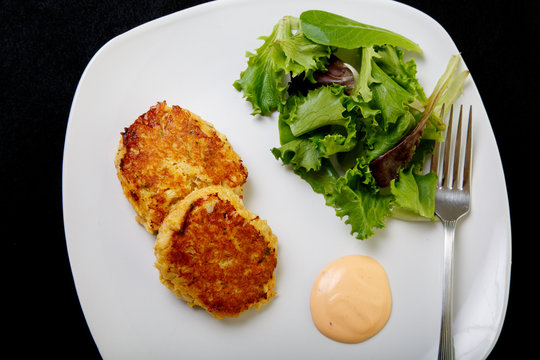 Crab Cakes And Salad On Black From Above