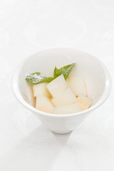 Fresh melon cubes with mint leaves