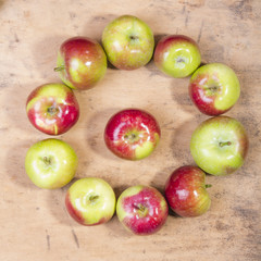 circle of apples on a wooden background, as a metaphor for time