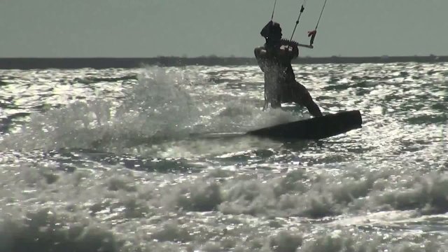 Kiteboarding, kitesurfing, action sport kiteboarding harnesses power of summer wind with a large controllable power kite to be propelled across water