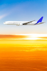 Fototapeta na wymiar Samolot na niebie o zachodzie słońca. Samolot pasażerski na niebie