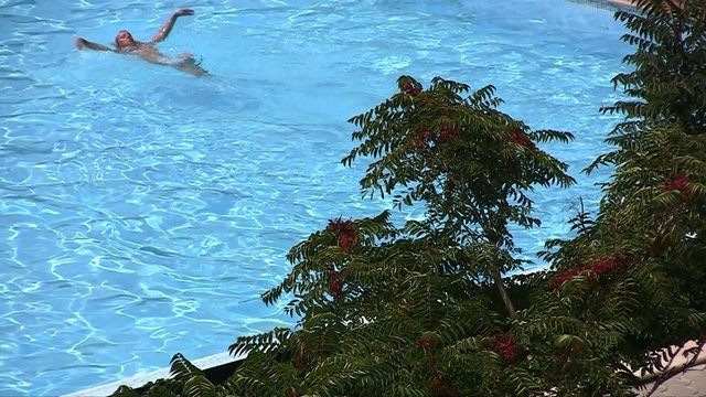 The beautiful girl floating in the pool