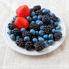Small plate with fresh summer berries - strawberry, blueberry an