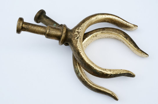 two bronze oarlocks on a light background