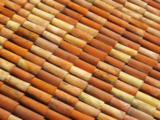Roof tiles in different colors from yellow to red.