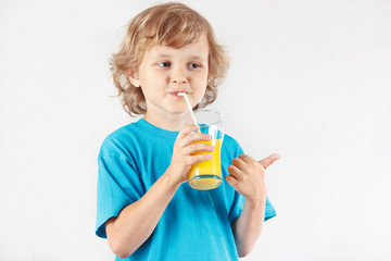 Beautiful blonde child drinking a fresh orange juice