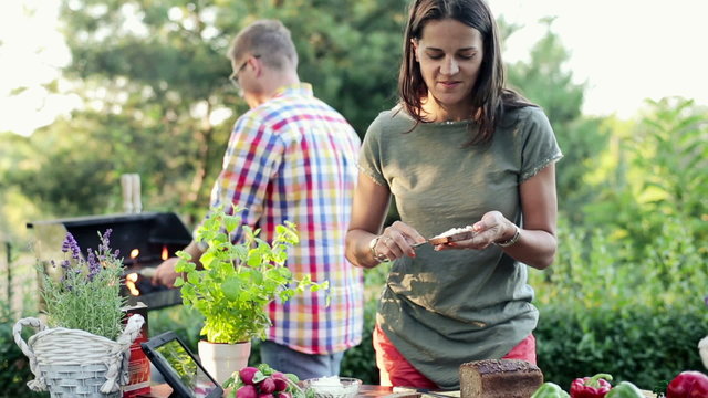 Happy woman eating tasty sandwith during grill