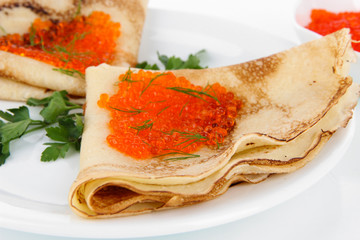 Delicious pancakes with red caviar isolated on white