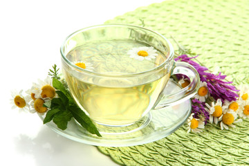 Cup of herbal tea with wild flowers and mint, isolated on white