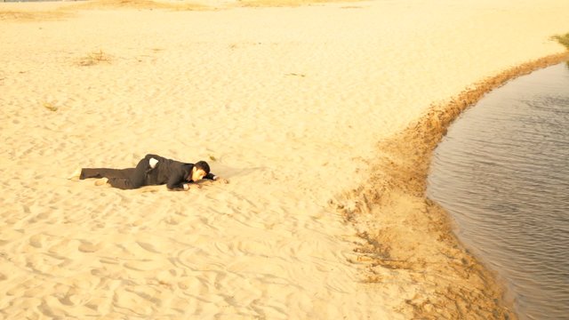 Businessman Crawling in Desert Reaching Water Success Concept
