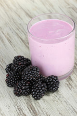 Sweet blackberries with yogurt on table close-up