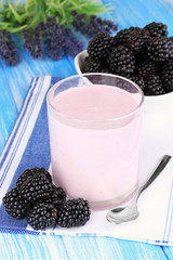 Sweet blackberries with yogurt on table close-up