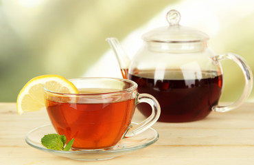 Cup of tea with lemon on table on light background