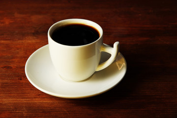 Cup of coffee on wooden table close-up
