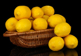 Ripe lemons in wicker basket isolated on black